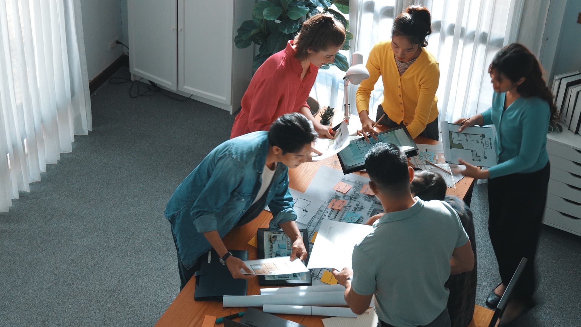 People clustered around a table filled with diagrams