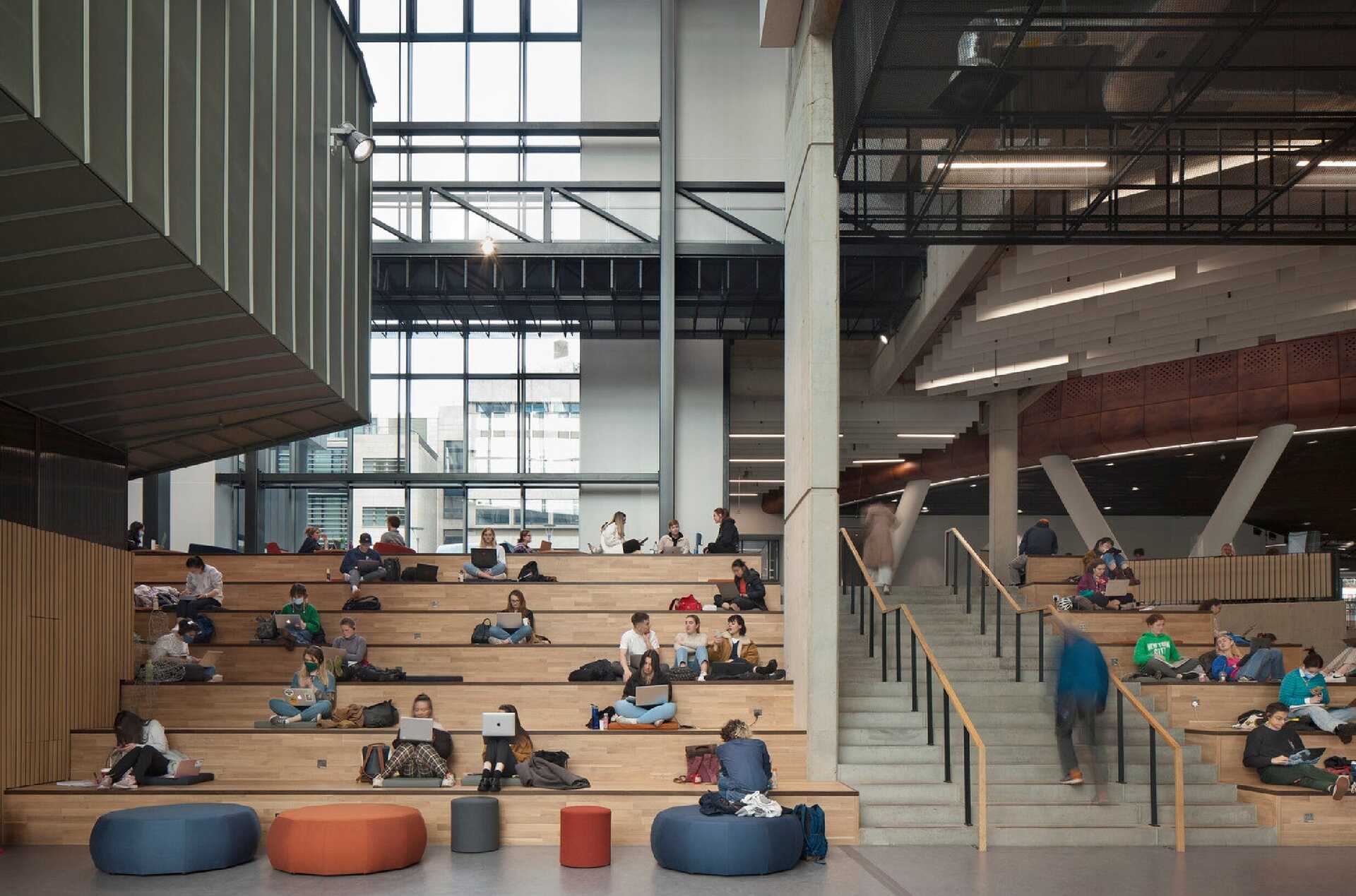 Students sitting on stairs with laptops